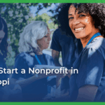 A smiling woman with curly hair wearing a blue lanyard is surrounded by diverse volunteers outdoors. Text overlay reads, “How to start a nonprofit in Mississippi.”