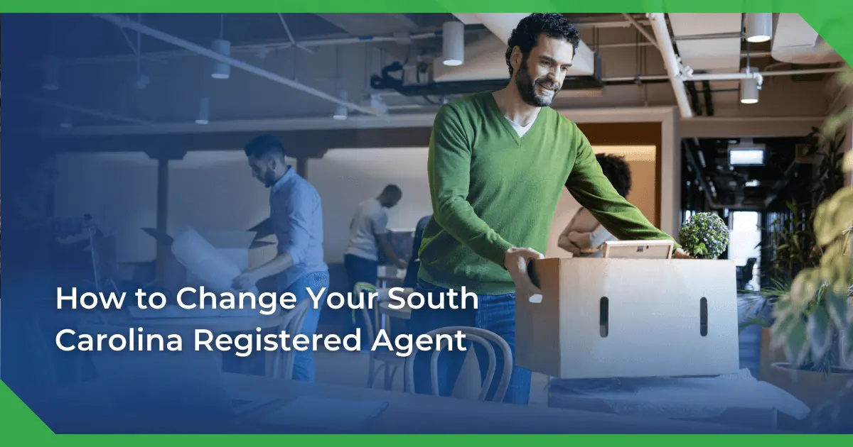 Man in a green sweater smiling and carrying a box in an office setting. Others are packing or working. Text reads South Carolina change of registered agent for a nonprofit.